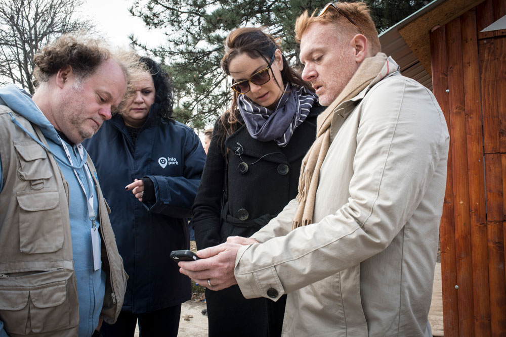 A man showing a group how to use a mobile phone. IRC/MJaques